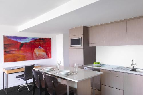 a kitchen with a table and chairs and a counter at Mantra South Bank Brisbane in Brisbane