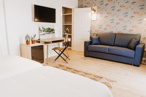 Hotel Mar Azul & Surf في سوانسيس: غرفة معيشة مع أريكة زرقاء وطاولة