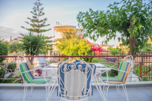 a table and chairs sitting on a balcony at Thiseos Georgia's Private Paradise in Lékhaion