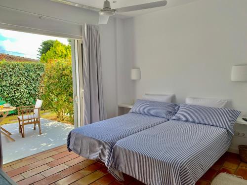 1 dormitorio con 1 cama y puerta que da a un patio en Habitación con jardín y terraza en el Tosalet, en Jávea