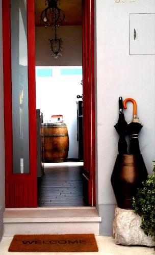 a red door leading into a room with a barrel at Guest House CorteMazzini36 in Cesenatico