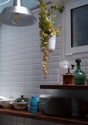 a kitchen with a shelf with dishes and a light at Guest House CorteMazzini36 in Cesenatico