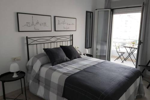 1 dormitorio con 1 cama grande y balcón en Campania, en Ourense