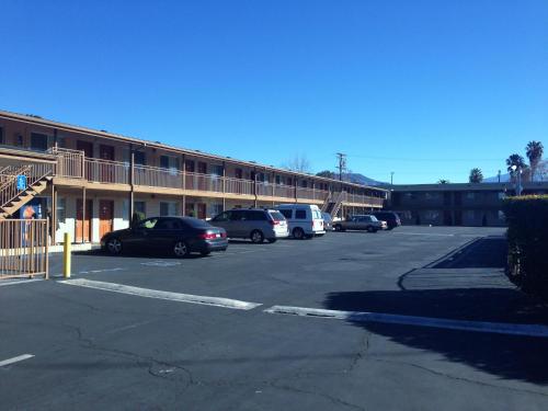 a parking lot with cars parked in front of a building at Downtown Motel 7 in San Bernardino