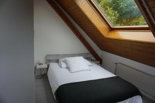 Bett in einem kleinen Zimmer mit Fenster in der Unterkunft Studio Maujobia 31 in Neuenburg