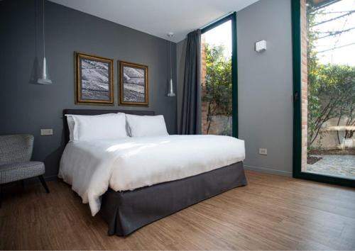 a bedroom with a large white bed and a window at Agrisuite Il Cedro in La Morra
