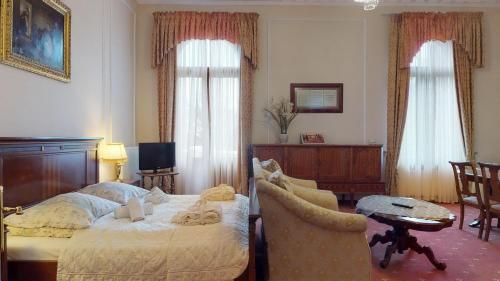 a bedroom with a bed and a table and a chair at Hotel Bursztynowy Pałac in Koszalin