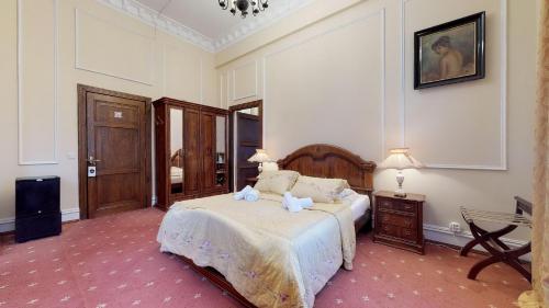 a bedroom with a bed and a table and a chair at Hotel Bursztynowy Pałac in Koszalin