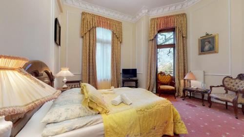 a bedroom with a large bed and a living room at Hotel Bursztynowy Pałac in Koszalin
