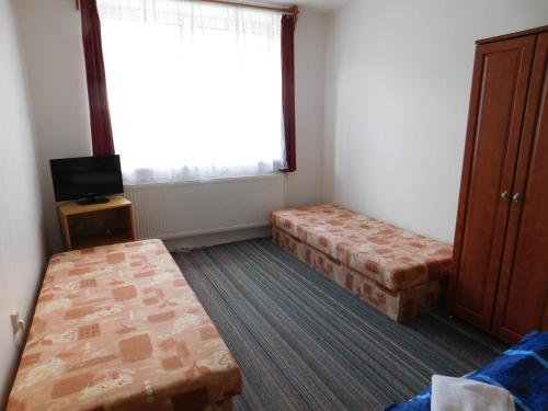 a small room with two beds and a window at Pension U Mojmíra in Rokytnice nad Jizerou