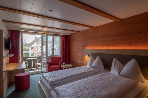 a hotel room with a bed and a balcony at Hotel Chalet Swiss in Interlaken