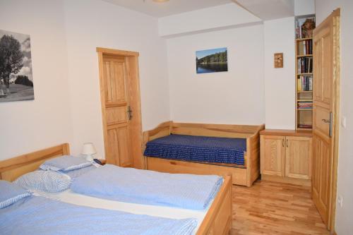 a bedroom with two beds and a book shelf at Apartman Razula in Velké Karlovice