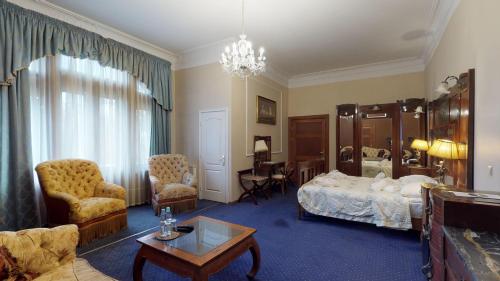 a hotel room with a bed and a table and chairs at Hotel Bursztynowy Pałac in Koszalin