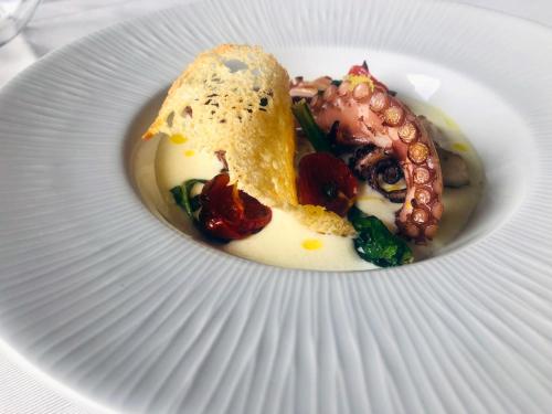a white plate with food on top at Magic Hotel in Atena Lucana