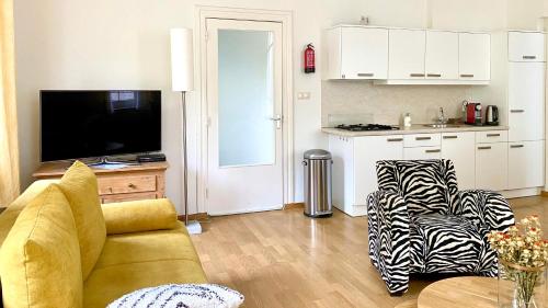 a living room with a couch and a kitchen at Appartement Scheepers in Valkenburg