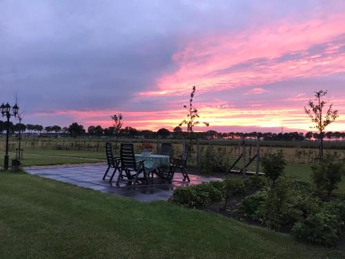 un patio con mesa y sillas al atardecer en B&B In ons straatje, en Rosmalen