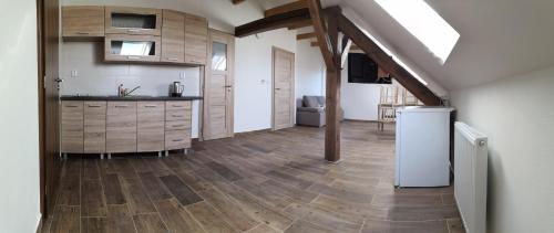 a kitchen with wooden floors and a kitchen with a refrigerator at Penzion Na Farmě in Karle