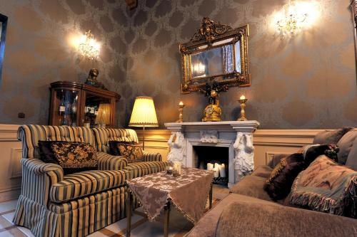 a living room with two couches and a fireplace at Hotel Bursztynowy Pałac in Koszalin