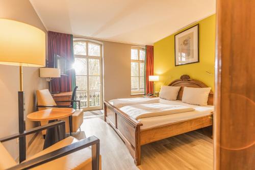 een kleine kamer met een bed en een stoel bij Hotel Bentheimer Hof in Bad Bentheim