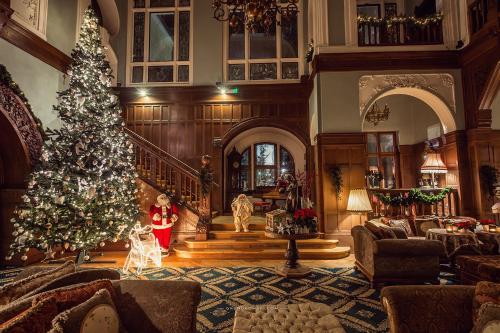 a living room with a christmas tree in a room at Hotel Bursztynowy Pałac in Koszalin