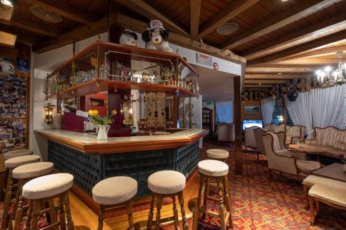 a bar with a bunch of stools in a room at Hotel Chalet Swiss in Interlaken