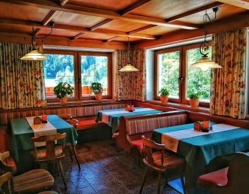 un restaurante con mesas, sillas y ventanas en Gwercherwirt, en Brandenberg
