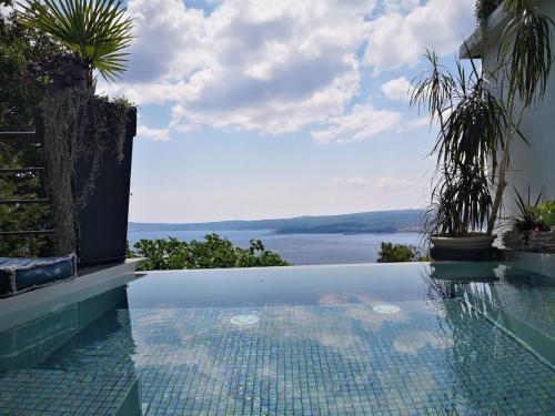 a swimming pool with a view of the water at Art Gallery House in Crikvenica