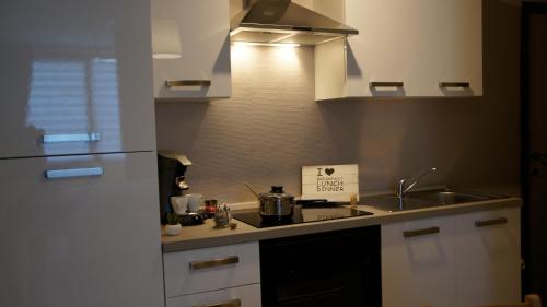 a small kitchen with a stove and a sink at Les petits nids de Nina 1 in Fosses-La-Ville