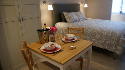 a table with two chairs and a table with a bed at Les petits nids de Nina 1 in Fosses-La-Ville
