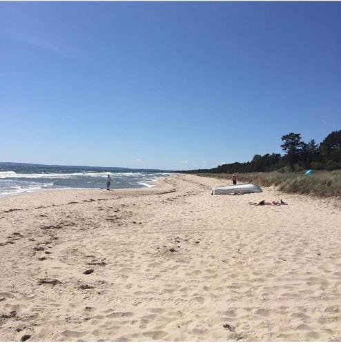 a beach with people laying on the sand and the ocean at Villa Sus & Dus in Yngsjö