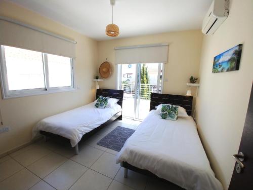two beds in a room with a balcony at AP10 Mythical Sands in Protaras