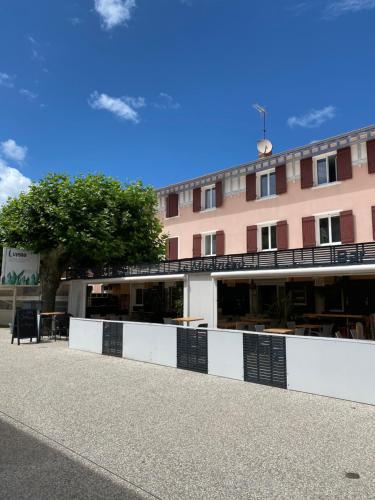 un edificio con una recinzione bianca e un albero di Boutique Hotel Lumaa Marinero a Vieux-Boucau-les-Bains