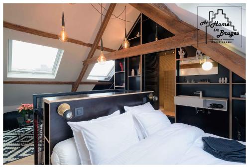 at Home in Bruges في بروج: غرفة نوم بسرير كبير ومخدات بيضاء