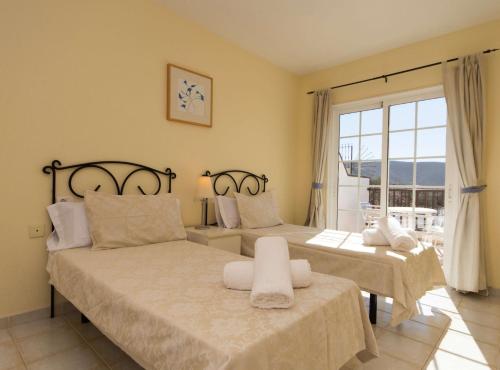 ロス・クリスティアーノスにあるFewo Jacquiのベッドルーム1室(ベッド2台、大きな窓付)