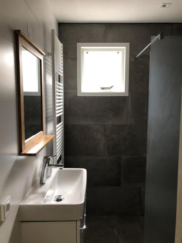 baño con lavabo y ventana en Appartement Waddengeluk Resort Amelander Kaap! en Hollum