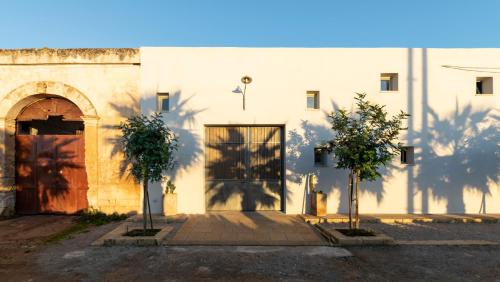 a building with a door and two trees in front of it at Galeta Masseria in Nardò