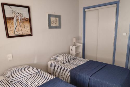 - une chambre avec 2 lits et une photo sur le mur dans l'établissement Belle villa sur vaste plage Palavas Montpellier, à Palavas-les-Flots