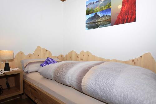 - une chambre avec un lit en bois dans l'établissement Haus Cosso, à Villabassa