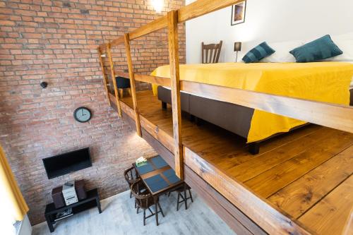 Dormitorio tipo loft con cama y pared de ladrillo en Milky Way Szczytna, en Toruń