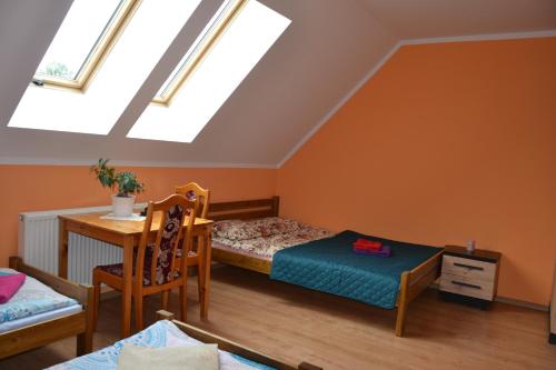 a attic room with a bed and a table at Gospodarstwo Agroturystyczne Damroka in Szymbark