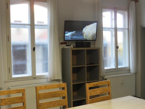 a living room with two windows and a flat screen tv at HERBERGE 28 Ferienwohnung für bis zu 6 Personen in Saalfeld