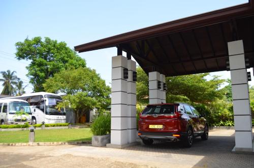 a red car is parked at a gas station at Nature Trails Boutique Hotel in Unawatuna