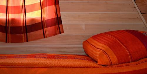 a bed with an orange pillow next to a window at Rafting Center Drina Tara in Bastasi
