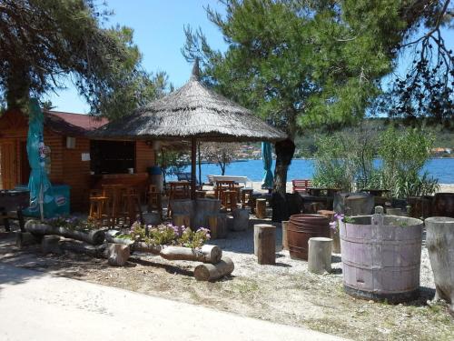 a hut with a table and chairs and flowers in front at Villa Frida in Sutomišćica
