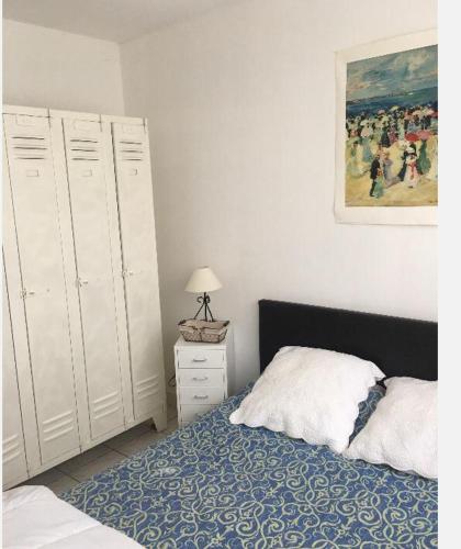 une chambre avec un lit et un tableau au mur dans l'établissement Appartement sympa Arcachon, à Arcachon