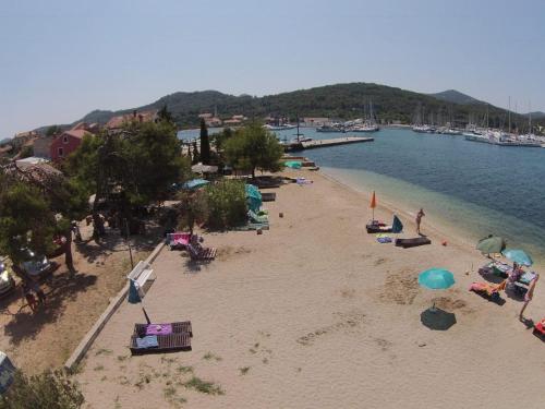 a beach with umbrellas and people on the sand at Villa Frida in Sutomišćica