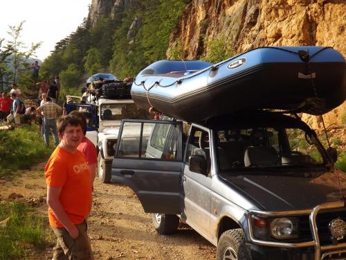 a man standing next to a truck with a canoe on the roof at Rafting Center Drina Tara in Bastasi