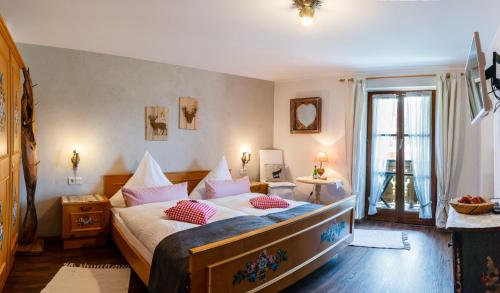 クリュンにあるFerienwohnung Bergfriedenのベッドルーム1室(ピンクの枕が付いた大型ベッド1台付)