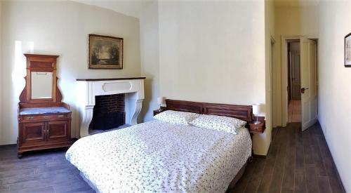 a bedroom with a bed and a fireplace at La Fornace in Garessio