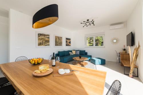 a kitchen and living room with a wooden table at Villa Belveder in Pag